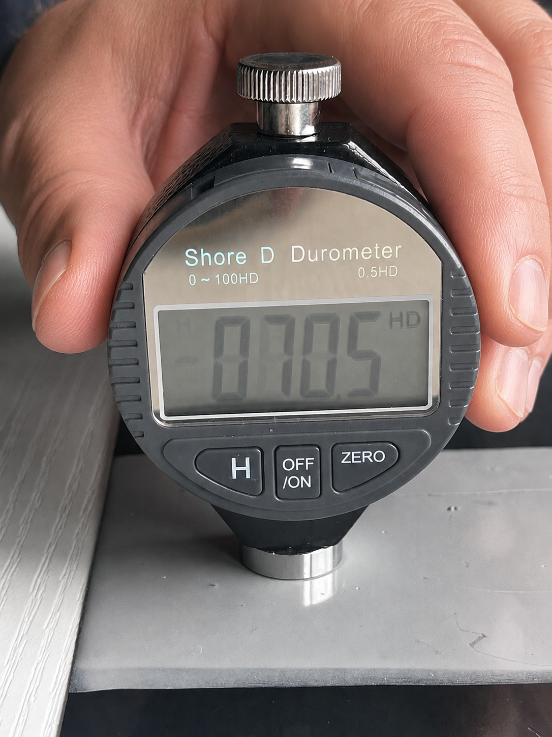 Step #3: Press the bottom probe flat against a samples coating - The device must be fully flat against the coating.